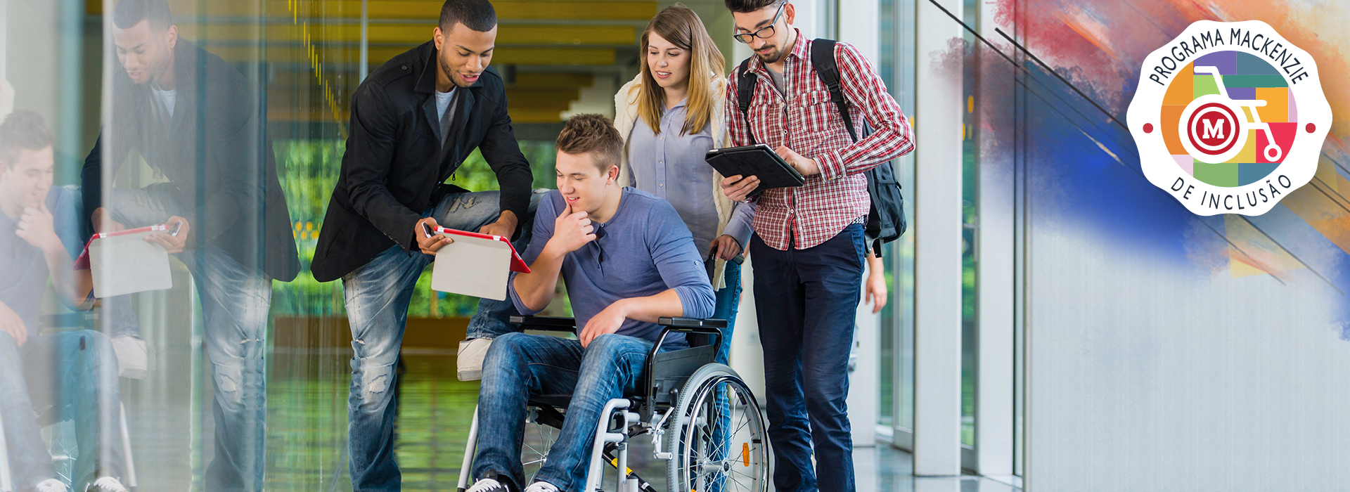 Quatro pessoas conversam e avaliam documento. Uma das pessoas, um homem, é cadeirante.