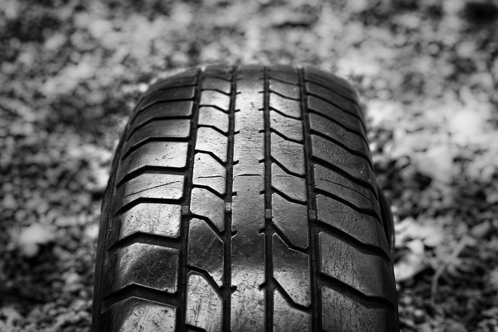 foto de um pneu contra um chão de pedregulhos - imagem em preto e branco