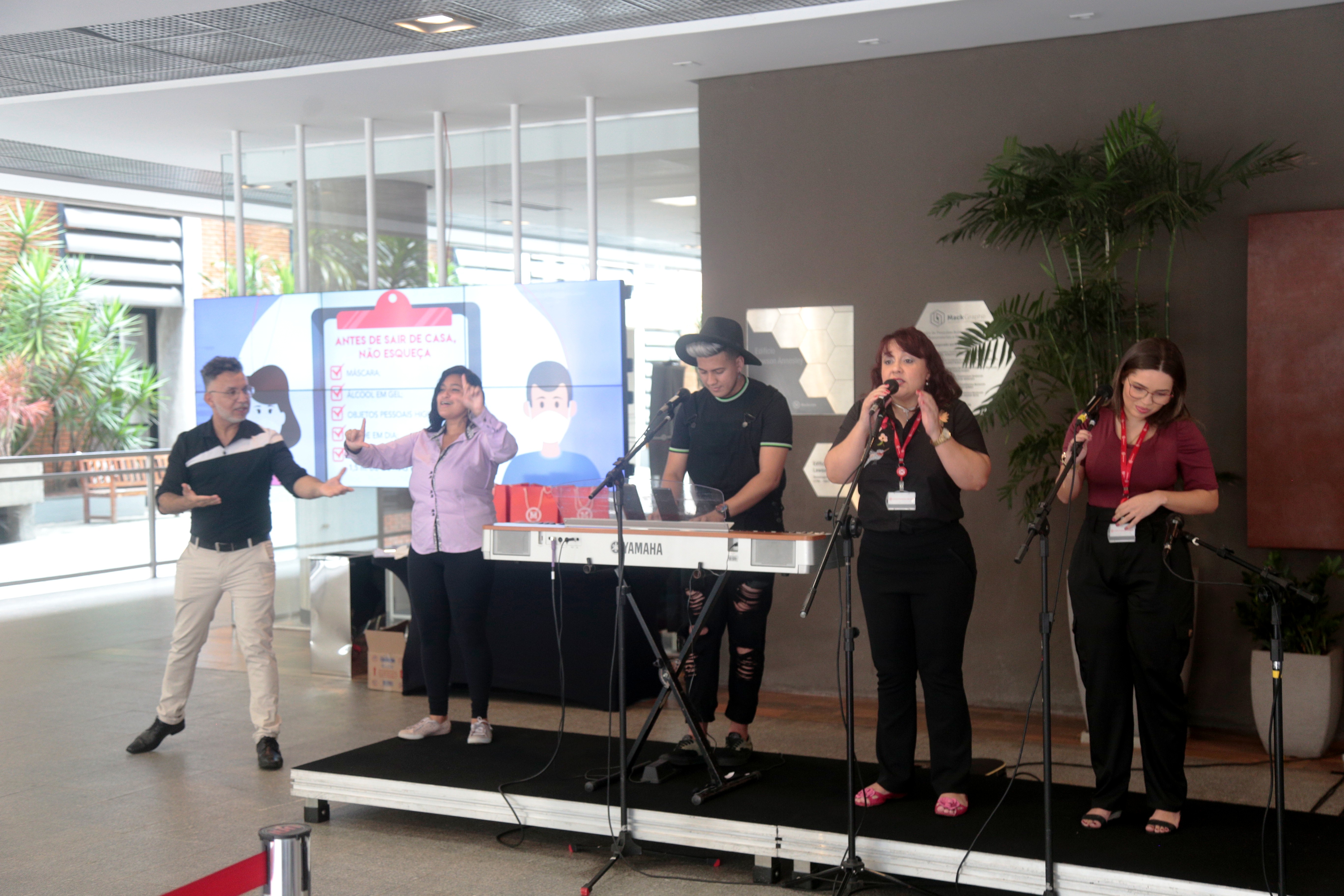 na imagem, cinco pessoas com instrumentos musicais se apresentam