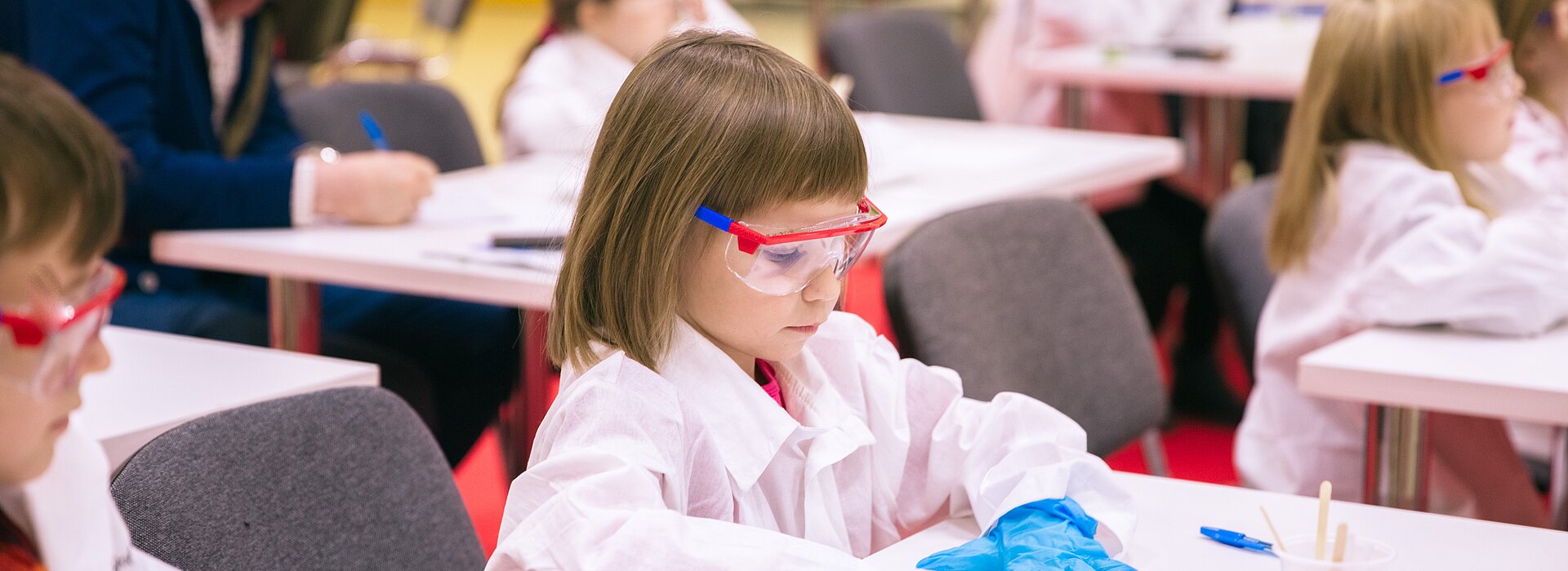 Criança sentada na mesa da sala de aula fazendo experimentos