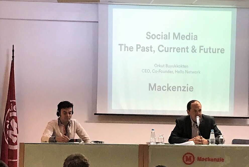 palestrante Orkut ao lado de professor da Universidade com slide ao fundo