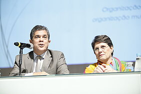 vice-reitor e diretora do CCBS sentados à mesa durante apresentação