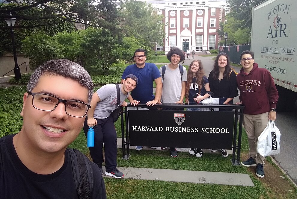 Selfie do professor Anderson com a turma de mackenzistas na placa de Harvard, com a universidade atrás. 