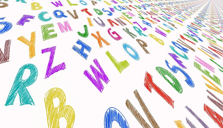 Diversas letras do alfabeto estão espelhadas pela foto. Elas têm diferentes cores e formatos.s