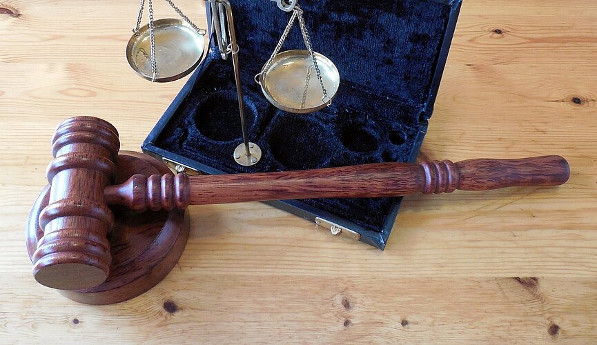 martelo de juiz ao da balança da justiça sobre uma mesa demadeira