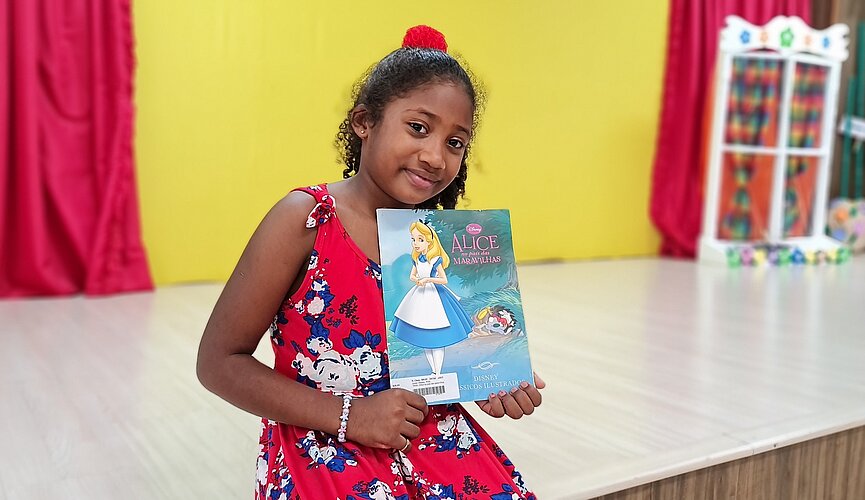 Aluna do Mackenzie Maria Júlya com um livro na mão