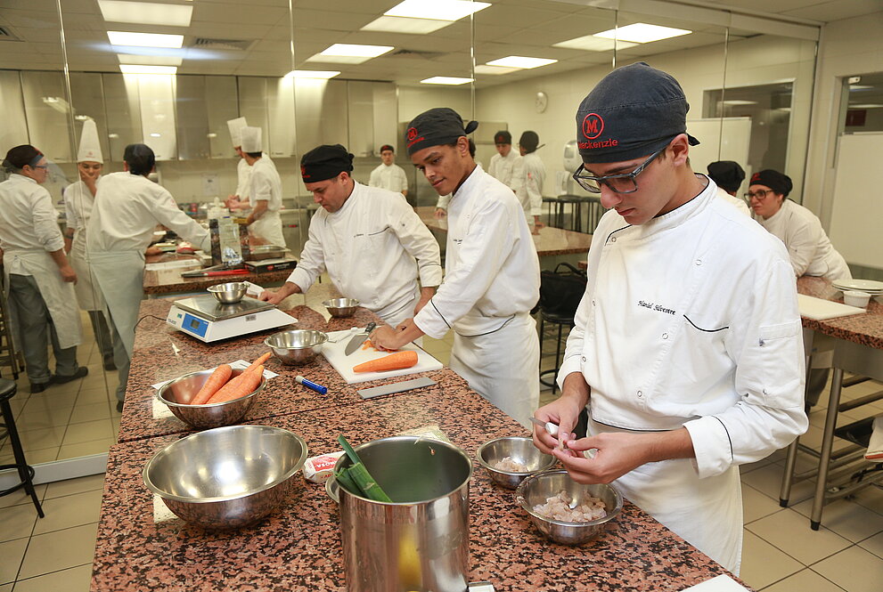 Alunos cozinhando durante o concurso.