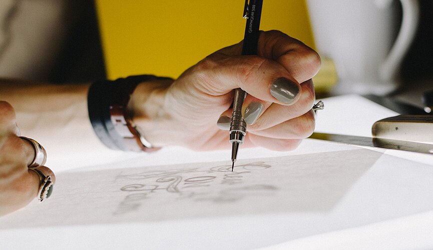 Foto de uma mão feminina desenhando.