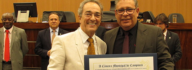 dois homens segurando diploma de homenagem