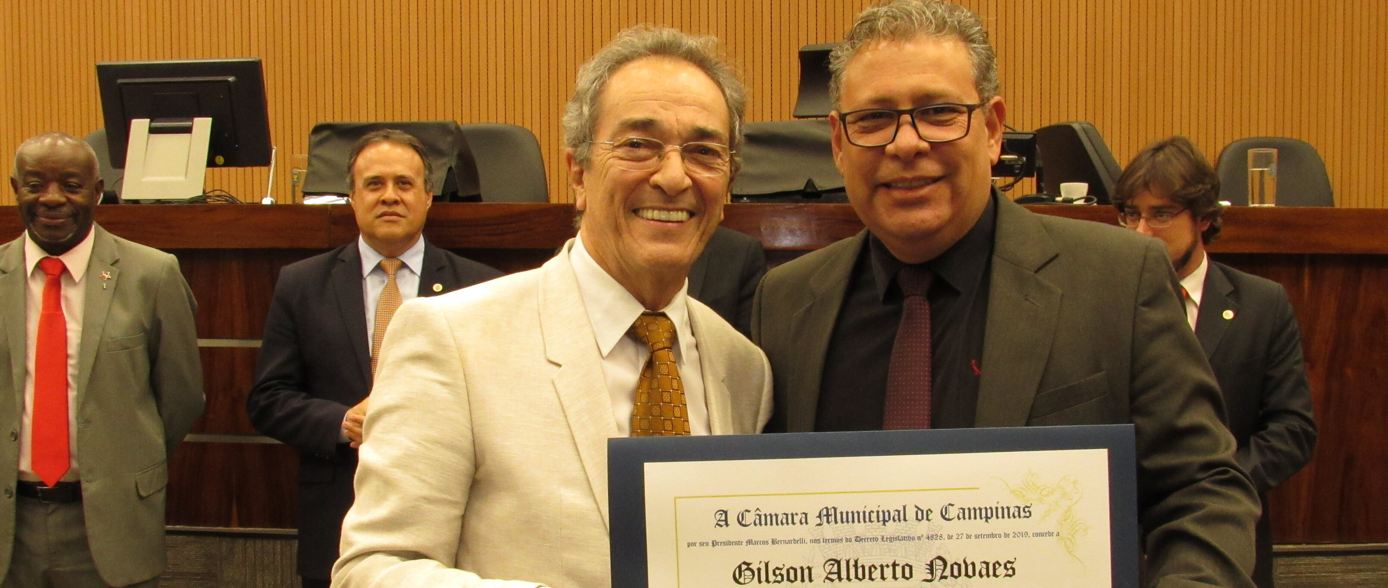 dois homens segurando diploma de homenagem
