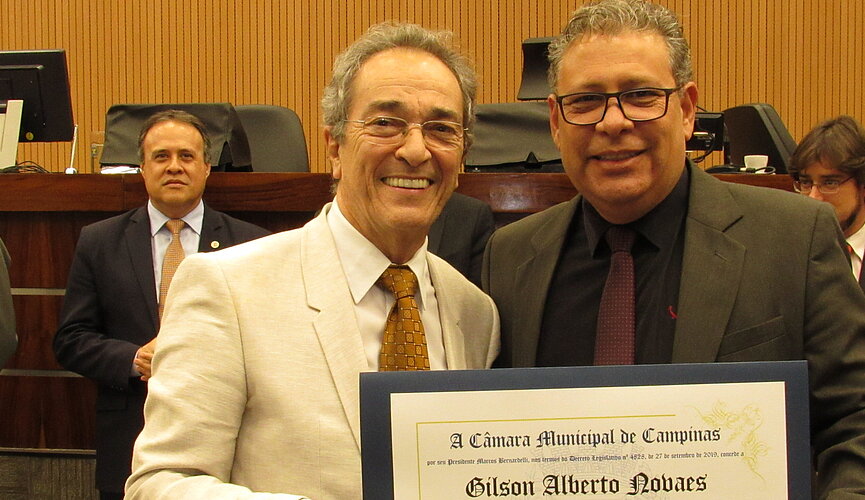 dois homens segurando diploma de homenagem