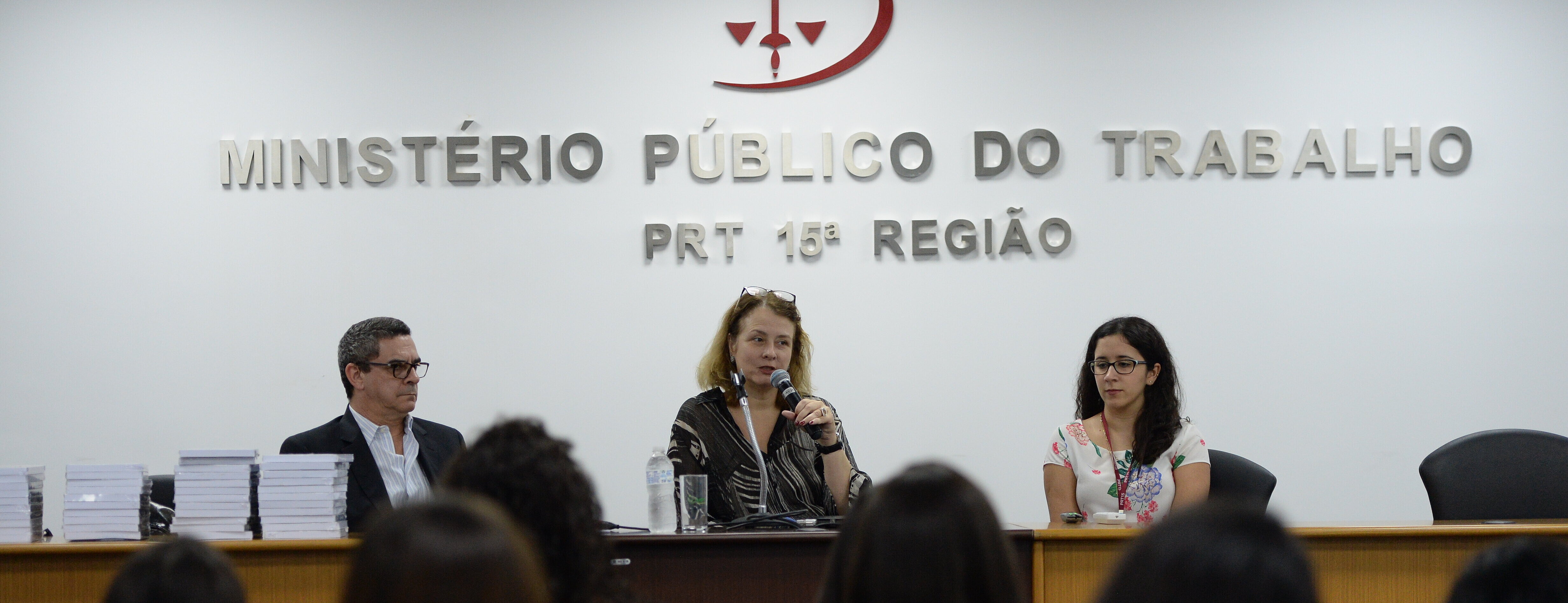 Ministério Público do Trabalho com três pessoas na mesa.