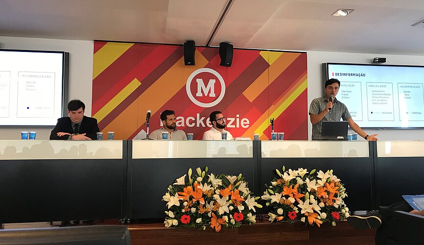 apresentadores compondo a mesa do evento