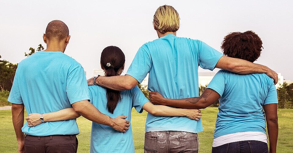 quatro pessoas de costas abraçadas