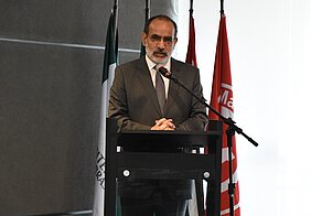 Ciro fala no microfone atrás do pulpito, localizado no palco em que aconteceu o evento, próximo a algumas bandeiras.