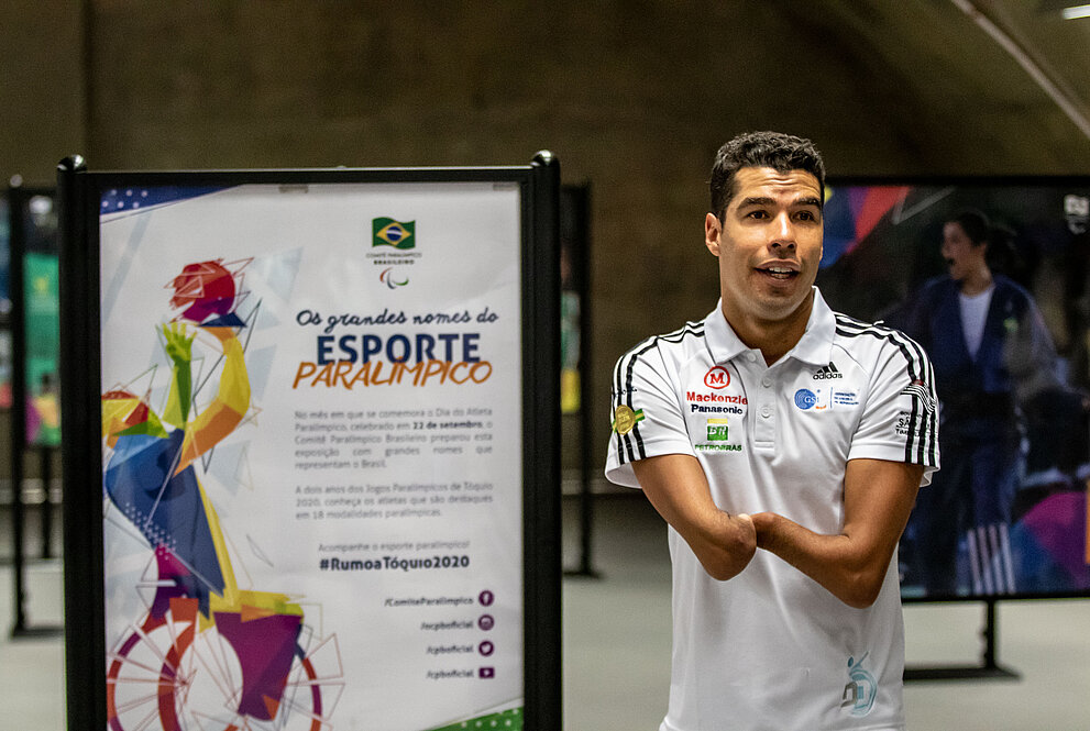 Daniel Dias, ao lado das fotos da exposição