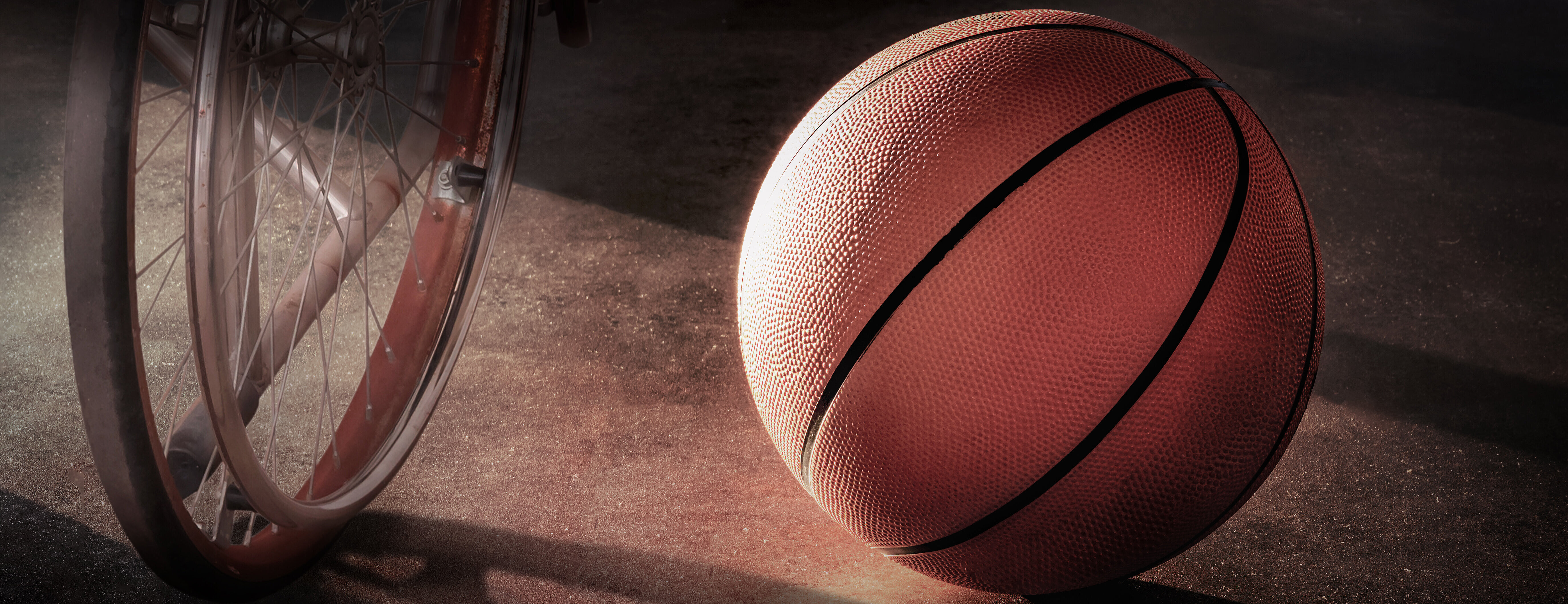Cadeira de rodas ao lado de bola de basquete.