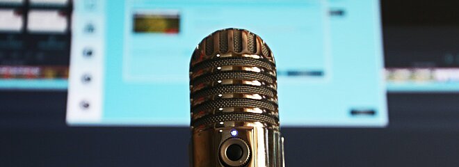 microfone e computador aberto em página de edição de um podcast 