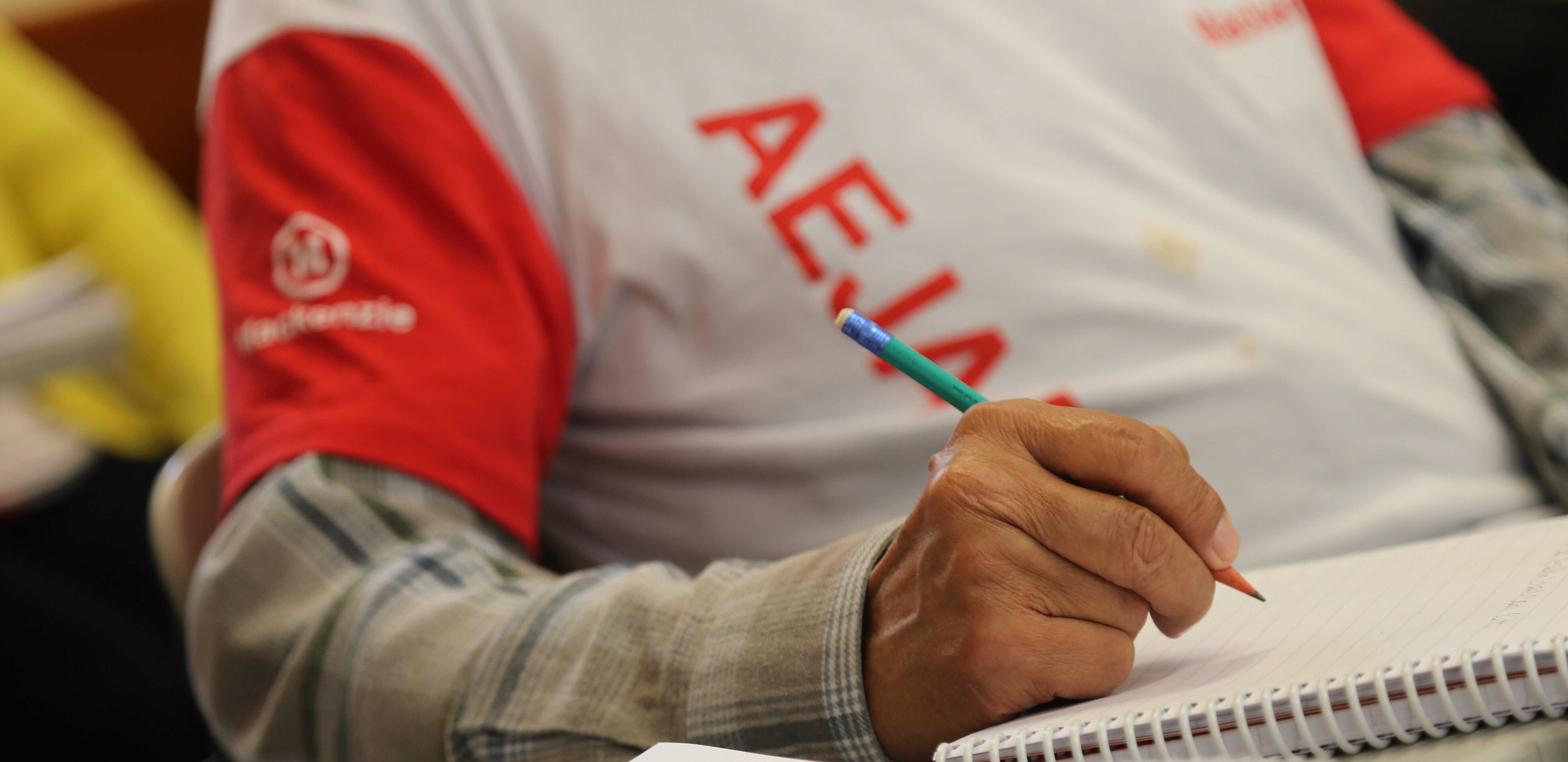 homem sentado estudando segurando lápis sobre o caderno