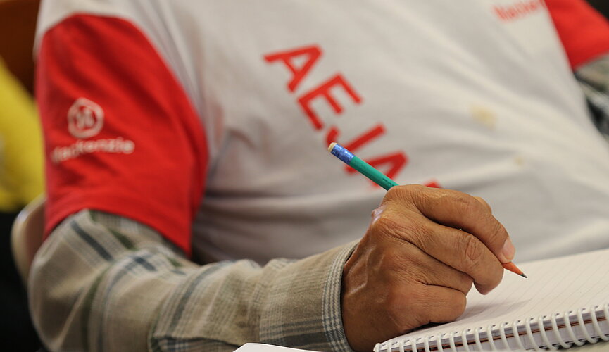 homem sentado estudando segurando lápis sobre o caderno