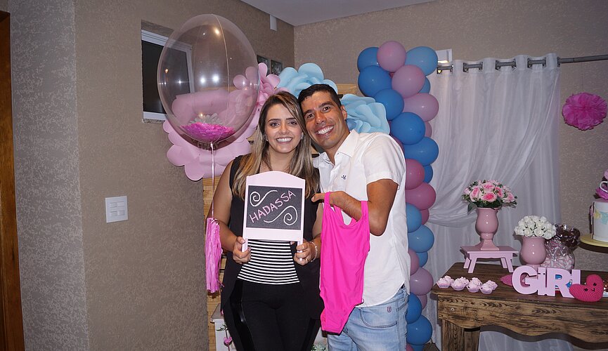 Daniel Dias e sua esposa Raquel Andrade segurando lousinha com o nome da filha