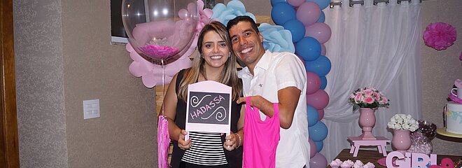 Daniel Dias e sua esposa Raquel Andrade segurando lousinha com o nome da filha