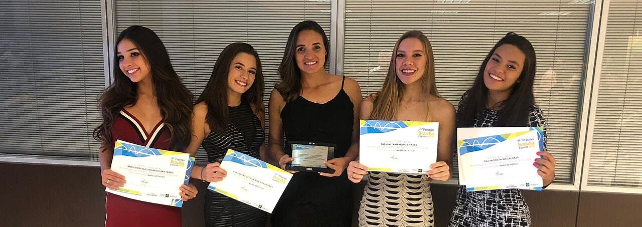 Atletas e treinadora recebem reconhecimento.