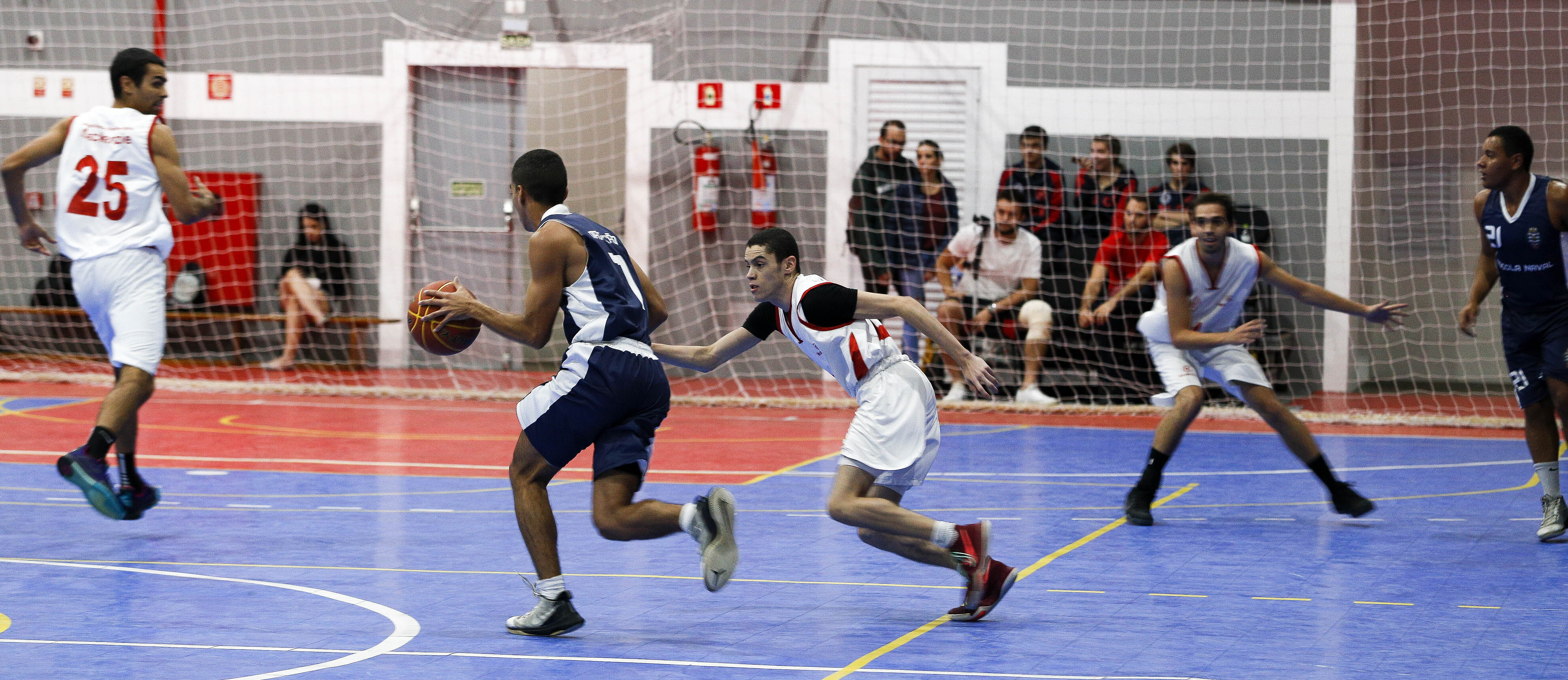 Jogadores do Mackenzie e da Escola Naval disputando basquete.