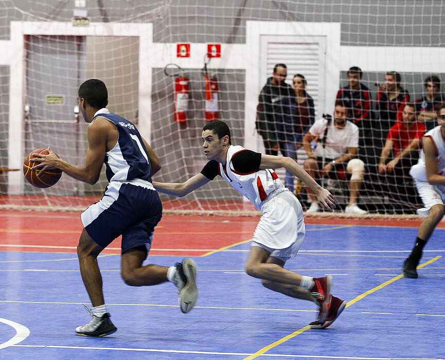 Jogadores do Mackenzie e da Escola Naval disputando basquete. 