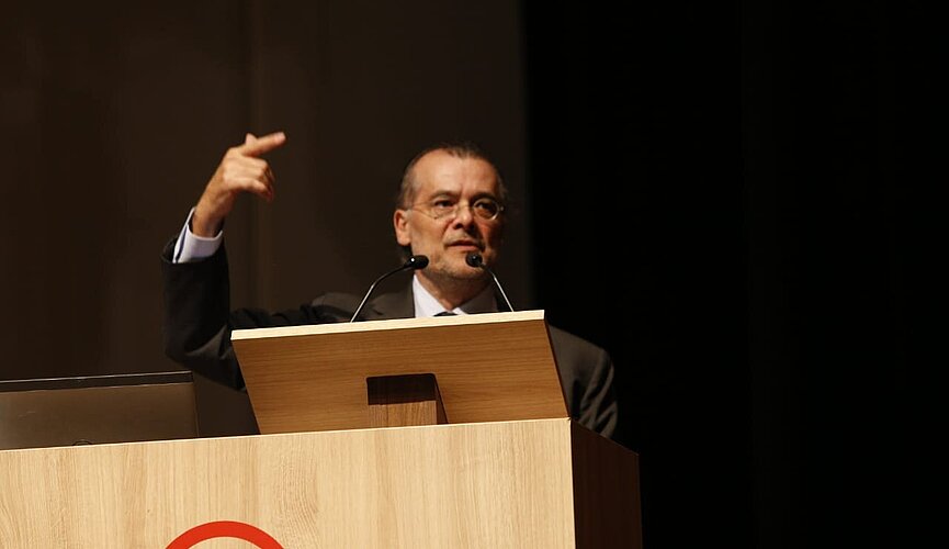 Gustavo Franco atrás do púlpito em sua palestra no auditório Ruy Barbosa
