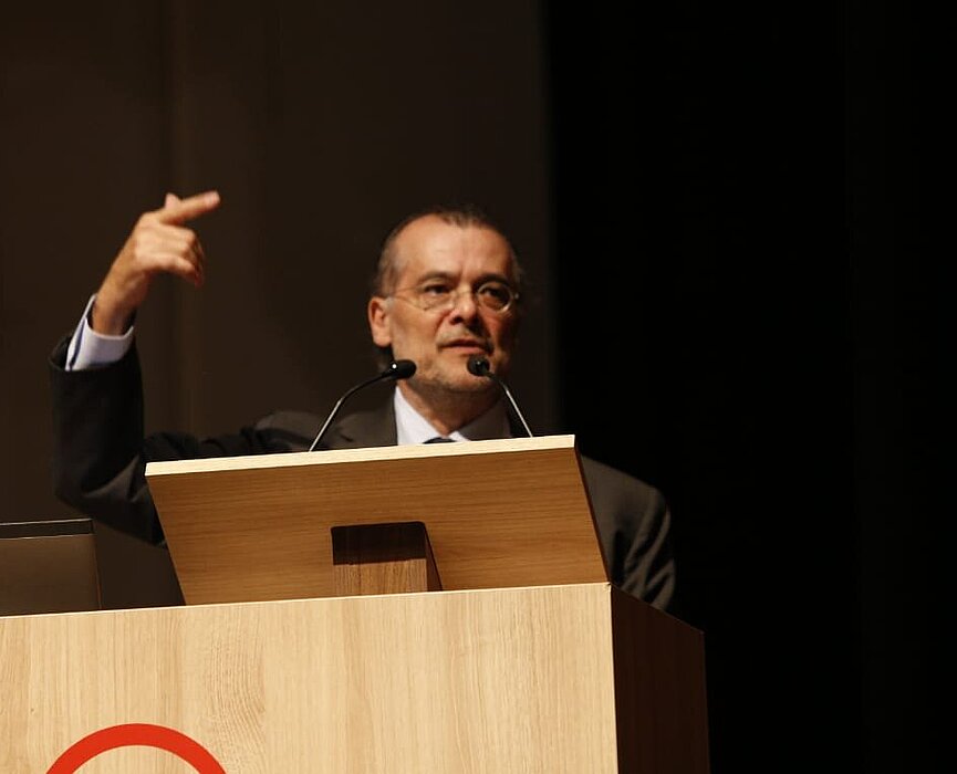 Gustavo Franco atrás do púlpito em sua palestra no auditório Ruy Barbosa