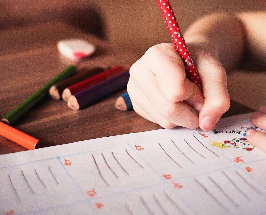 menina desenhando em papel com lápis coloridos