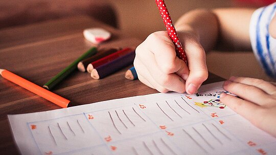menina desenhando em papel com lápis coloridos