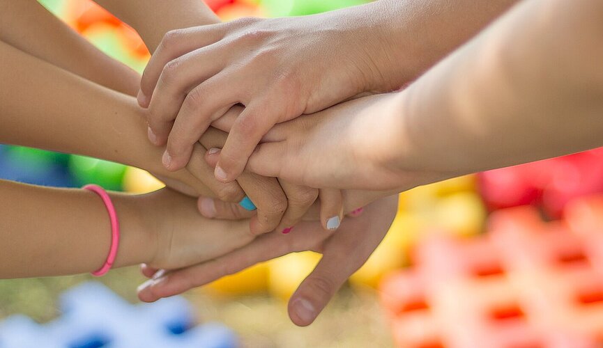 Mãos de crianças juntas.