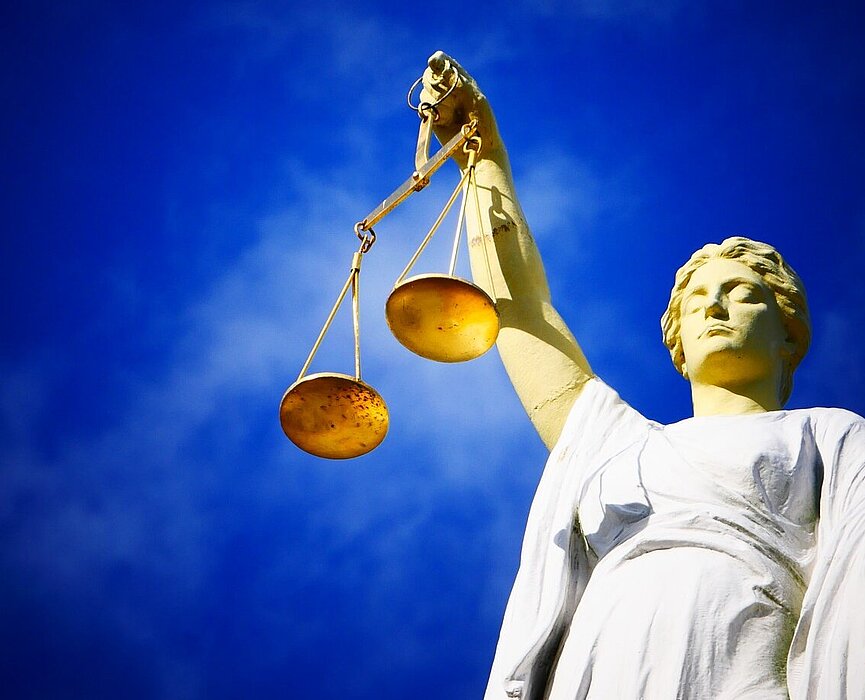 Imagem de uma estátua segurando uma balança, objeto símbolo do julgamento.