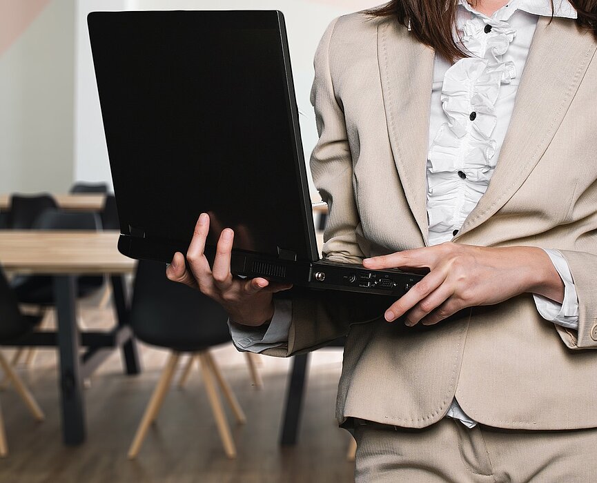 mulher segura laptop de maneira solícita