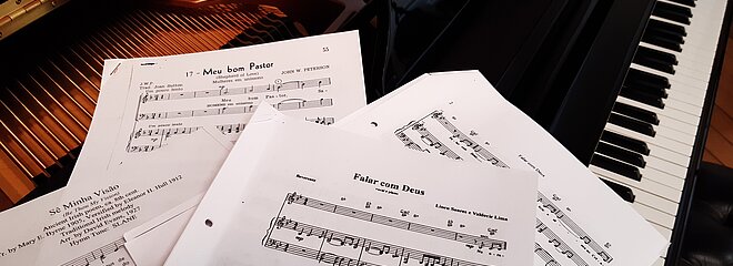A imagem apresenta partituras de piano. 