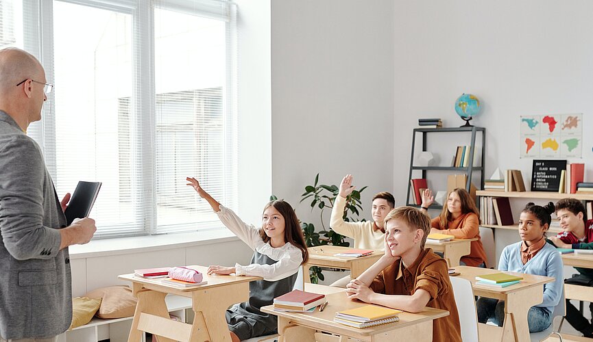 Professor e crianças na sala de aula enpolgadas para aprender