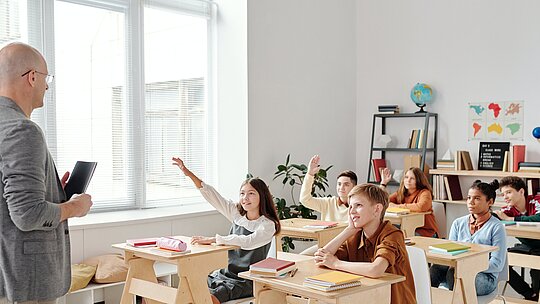 Professor e crianças na sala de aula enpolgadas para aprender