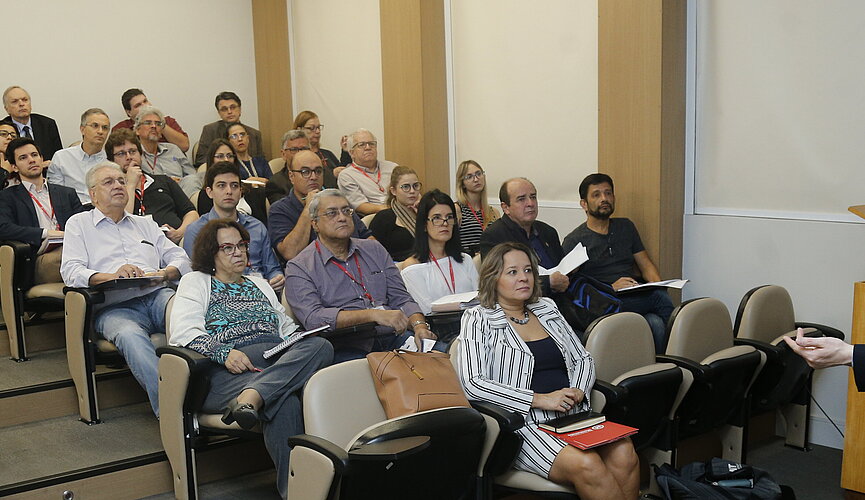 Platéia sentada nas cadeiras, ouvindo o palestrante da Coventry University.
