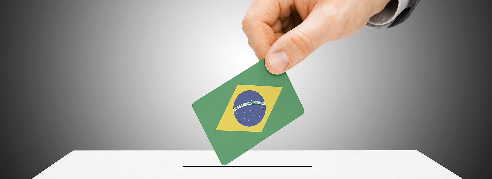 mão coloca voto com bandeira do Brasil em urna