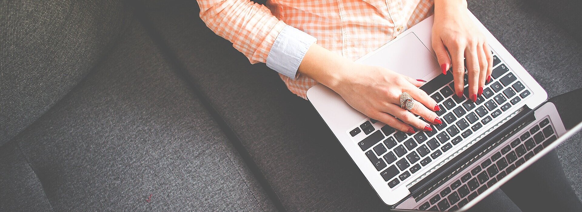 aluna sentada no sofá com laptop no colo