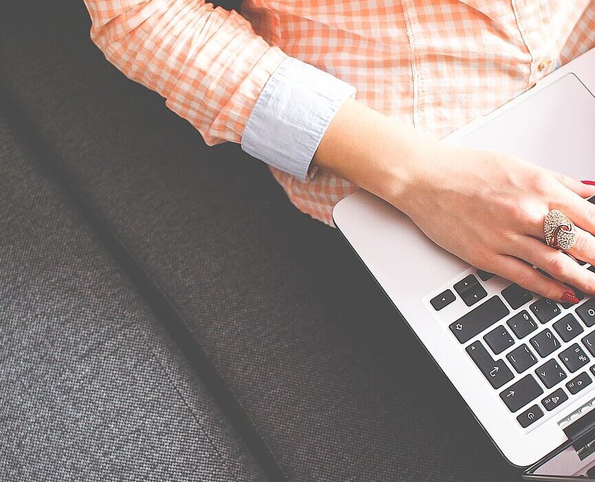 aluna sentada no sofá com laptop no colo