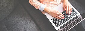 aluna sentada no sofá com laptop no colo