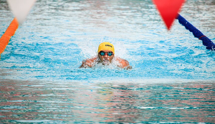 Nadador treinando em piscina olímpica. 