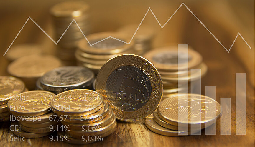 Moedas de real empilhadas sobre mesa de madeira