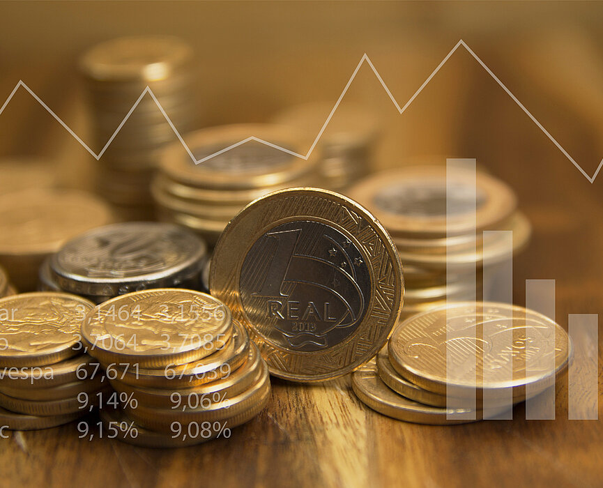 Moedas de real empilhadas sobre mesa de madeira