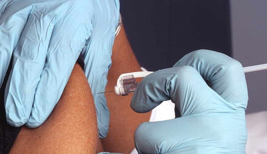 pessoa aplicando injeção no braço de uma outra pessoa