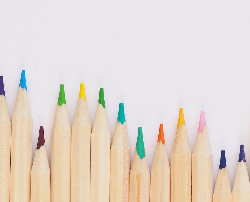 Vários lápis de cor na parede branca