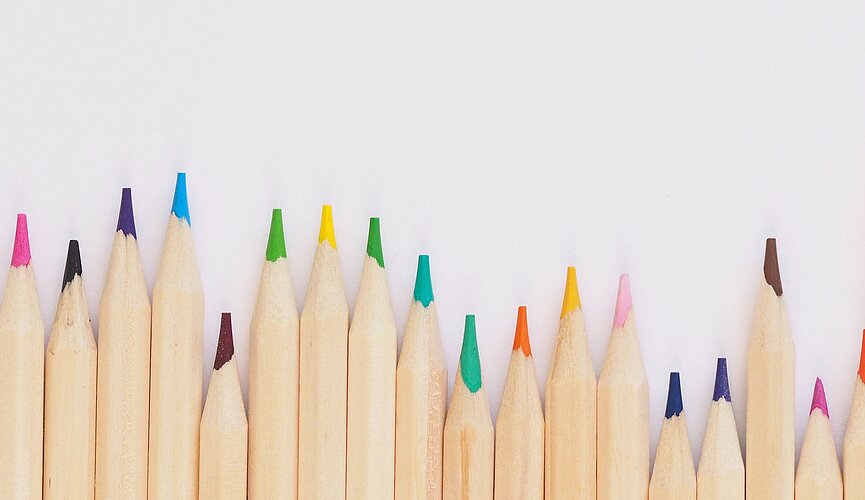 Vários lápis de cor na parede branca